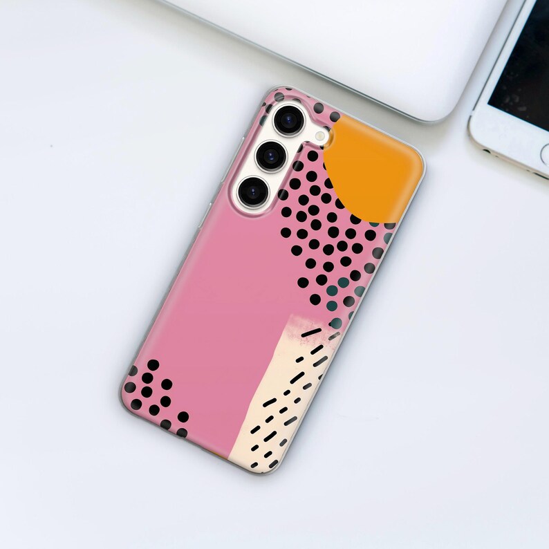 May include: A pink phone case with a black and white polka dot pattern, a yellow circle, and a white abstract design.