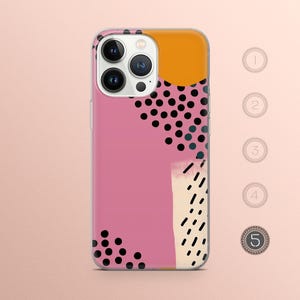 May include: A pink phone case with a black and white abstract design. The design features polka dots, lines, and a yellow circle.