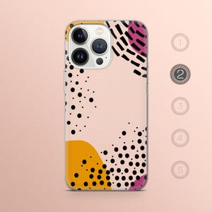 May include: A phone case with a pink, yellow, and black abstract design. The design features polka dots, lines, and abstract shapes.