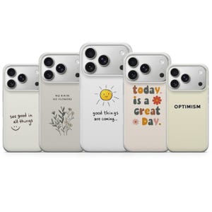 Pode incluir: Uma coleção de cinco capas de telemóvel com vários designs e mensagens inspiradoras. As capas são principalmente branco sujo com molduras de câmera prateadas. Os designs incluem um rosto sorridente, ilustrações florais e frases motivacionais.