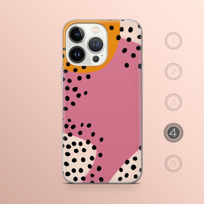 May include: A clear phone case with a pink, white, and yellow abstract design featuring black polka dots.
