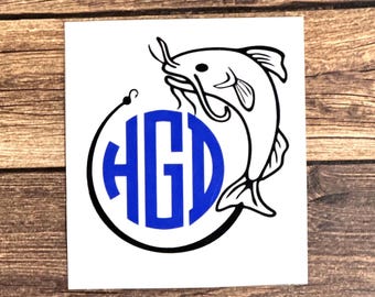 May include: A black and white silhouette of a catfish jumping out of a circle with the letters "HGD" in blue inside the circle.