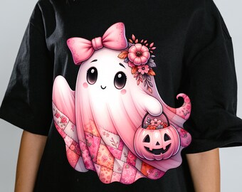 May include: Black t-shirt with a pink ghost illustration. The ghost has a bow, flowers, and a pumpkin bucket. The lower part of the ghost has a patchwork design. A whimsical Halloween design.