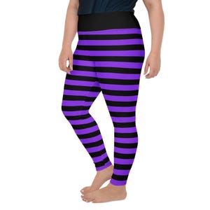 May include: Black and purple striped leggings. The leggings have a wide black waistband and are made of a stretchy material. The stripes are horizontal and evenly spaced. The leggings are form-fitting and reach the ankles.