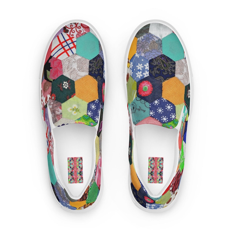 May include: A pair of white canvas slip-on shoes with a colorful patchwork design. The design features a variety of fabrics in different colors and patterns, including hexagons, flowers, and geometric shapes.