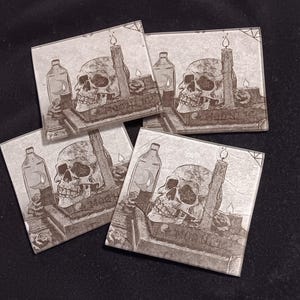 May include: Set of four square glass coasters with a black and white illustration of a skull, a bottle, and a candle. The illustration is on a brown background.