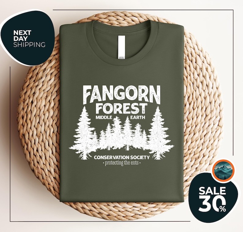 a green t - shirt with a forest scene on it