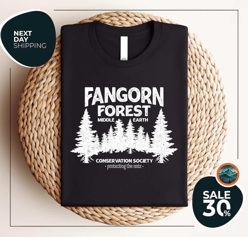 a black t - shirt with a forest scene on it