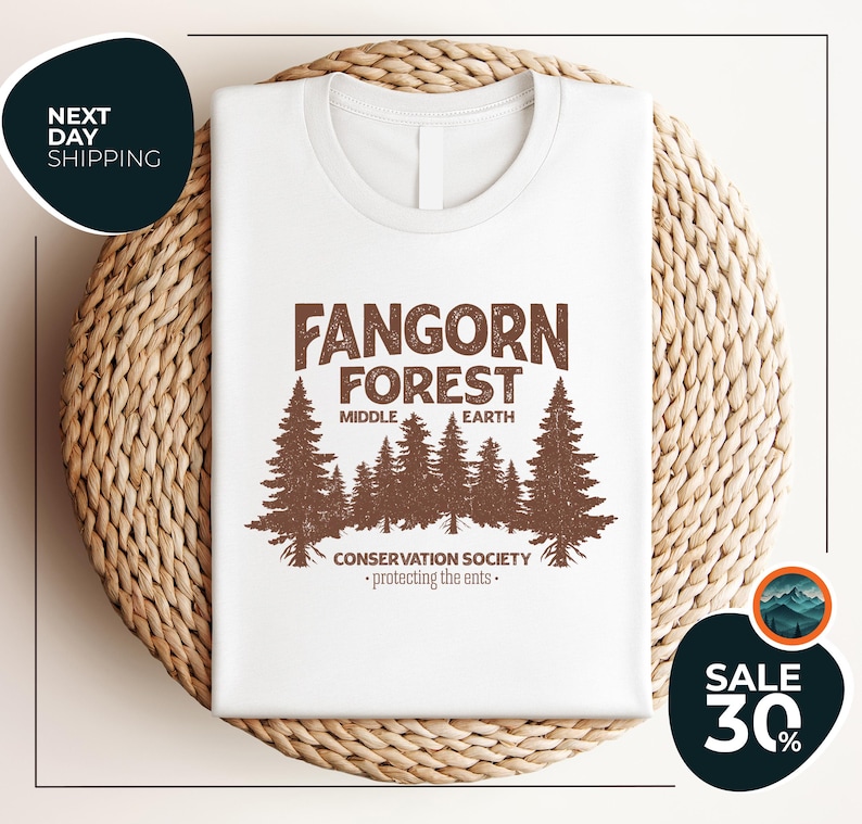 a white t - shirt with a forest scene on it