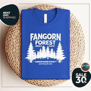 a blue t - shirt with a forest scene on it