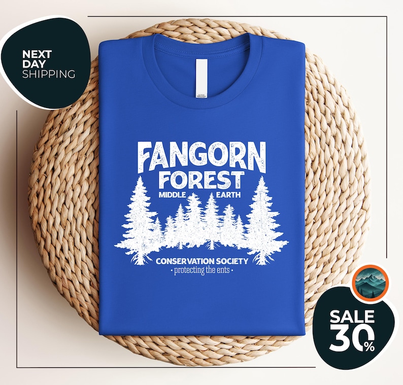 a blue t - shirt with a forest scene on it