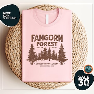 a pink t - shirt with a forest scene on it