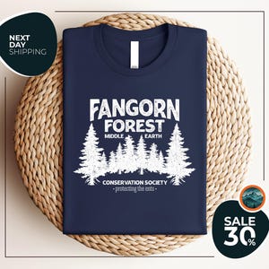 a blue t - shirt with a forest scene on it