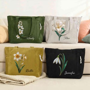 May include: Four corduroy tote bags in green, beige, mustard yellow, and black. Each bag features a floral design and a name: Wendy, Alice, Bella, and Jennifer. The bags have side pockets and white zipper pulls.