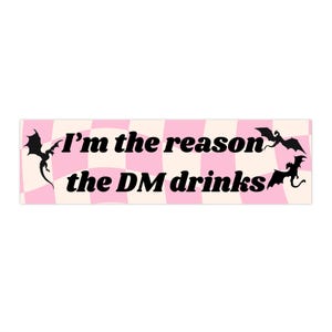 May include: A rectangular sticker with a pink and white checkered background. The text "I'm the reason the DM drinks" is in black, with black dragon silhouettes on each side.