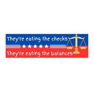 以下が含まれることがあります： 白の星と「They're eating the checks They're eating the balances」というテキストが書かれた青と赤の横断幕。右上に金の天秤が描かれている。