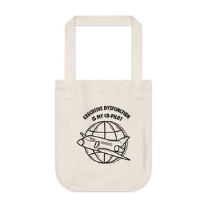 May include: Cream-coloured tote bag featuring a black graphic and text. The text says "EXECUTIVE DYSFUNCTION IS MY CO-PILOT" above a plane circling a globe. The bag has two handles.