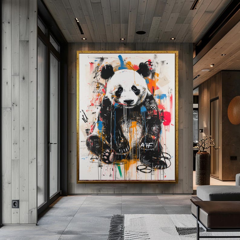 May include: A colourful abstract painting of a panda bear with black and white fur. The panda is sitting down with its paws in front of it. The background is a white canvas with splashes of colour, including red, blue, green, yellow, and orange.
