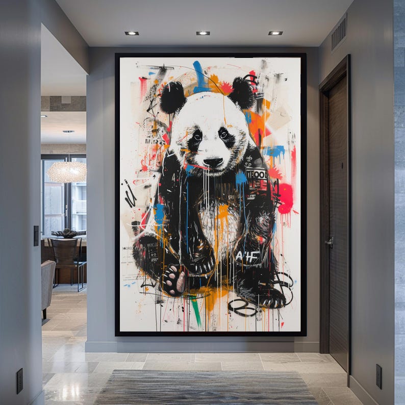 May include: A colourful abstract painting of a panda bear with black and white fur. The panda is wearing a blue and black jacket with graffiti-style text and symbols. The background is a white canvas with splashes of colour, including red, orange, yellow, green, and blue.