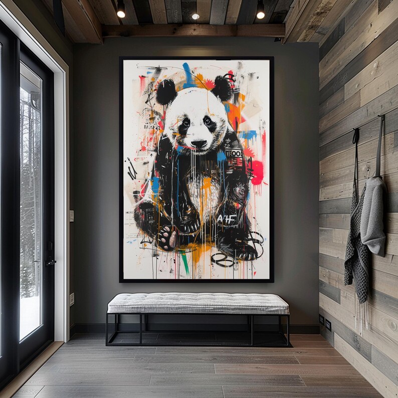 May include: A black and white panda bear wearing a jacket with colourful paint splatters in the background. The panda is sitting down with its paws crossed. The text "TRO" and "AIF" are visible on the jacket.