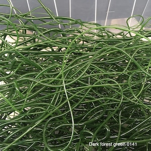 May include: A tangled mass of dark forest green, flexible tubing with a thin white stripe running along its length. The tubing is densely packed, creating a textured, organic appearance. The text "Dark forest green 0141" is visible in the bottom right corner.