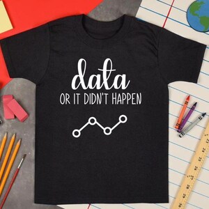 May include: Black t-shirt with white text that reads "data or it didn't happen" and a line graph.
