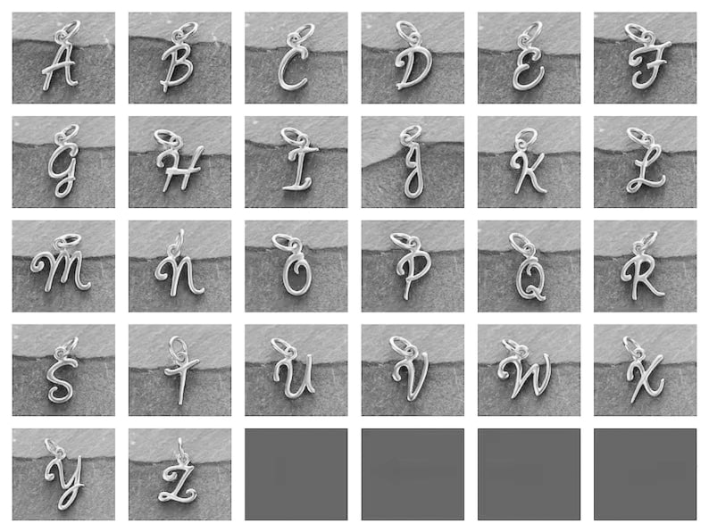 K&ouml;nnte beinhalten: Ein Satz von 26 silbernen Anh&auml;nger, jeder mit einem anderen Buchstaben des Alphabets in einer kursiv geschriebenen Schrift. Die Anh&auml;nger sind in alphabetischer Reihenfolge auf einem grauen Hintergrund angeordnet.