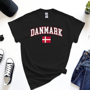 May include: Black t-shirt with white text that says "DANMARK" and a red and white Danish flag.