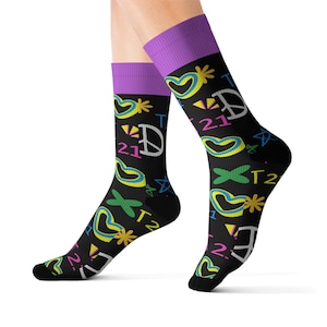 May include: A pair of black socks with a colorful pattern of hearts, peace signs, stars, and the number 21. The socks have a purple cuff.