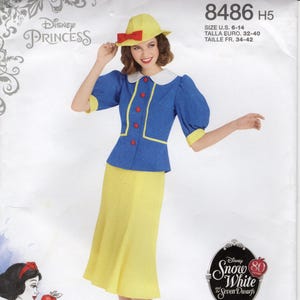 Può includere: Modello per costume di Biancaneve. L'immagine mostra una donna che indossa una giacca blu con finiture gialle e una gonna gialla. La giacca ha bottoni rossi. Un cappello giallo con un fiocco rosso è sulla sua testa. Il modello è di Simplicity.