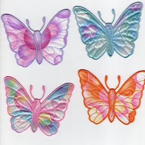 May include: Four colorful butterfly appliqués. Each butterfly has a unique design with shades of pink, purple, blue, orange, and yellow. The wings have a quilted texture with detailed stitching, and the bodies are a matching color.