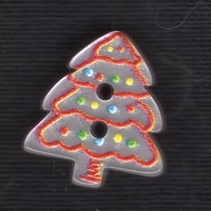 Puede incluir: Un botón en forma de árbol de Navidad con una superficie transparente y texturizada. El botón está delineado en rojo con detalles rojos, amarillos y azules. El botón tiene tres agujeros y está sobre un fondo negro.