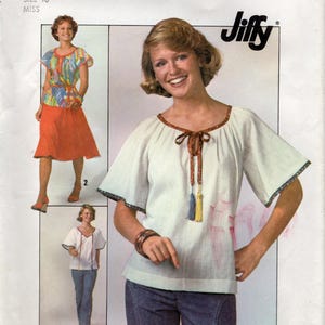 May include: Simplicity sewing pattern 7964 featuring a woman wearing a white top with a brown trim and blue jeans. The pattern includes a skirt and top ensemble and a second top and jeans outfit. The word "Jiffy" is printed on the pattern.