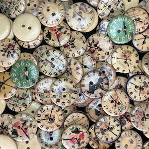 May include: A collection of wooden buttons with clock faces and floral designs. The buttons feature a variety of clock faces with Roman numerals and hands, some with floral accents in pink, green, and cream. The buttons are round with two holes for sewing.
