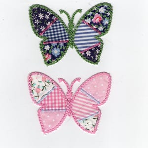 May include: Two fabric butterfly appliqués. One butterfly has navy blue floral, blue and white striped, and gingham patterns. The other butterfly is pink with polka dots, stripes, and floral patterns. Both have green and pink crocheted edges.