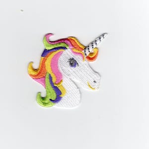 May include: Embroidered unicorn patch featuring a white head with a rainbow mane in shades of orange, yellow, pink, green, and purple. The unicorn has a silver horn with black stripes and a smiling expression. This patch is ideal for adding to clothing or accessories.