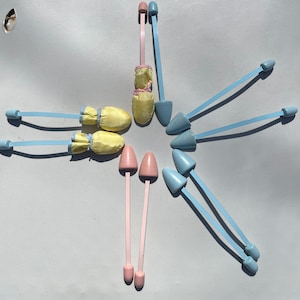 May include: A set of eight shoe trees in various colors. The shoe trees are made of plastic and have a spring-loaded mechanism. There are two pink shoe trees, two light blue shoe trees, and four yellow shoe trees.