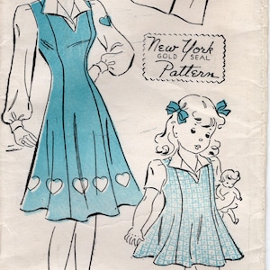 May include: A vintage sewing pattern for a dress with a heart applique. The pattern is for sizes 14-32 and is from New York Gold Seal Pattern. The pattern is illustrated with two women wearing the dress.
