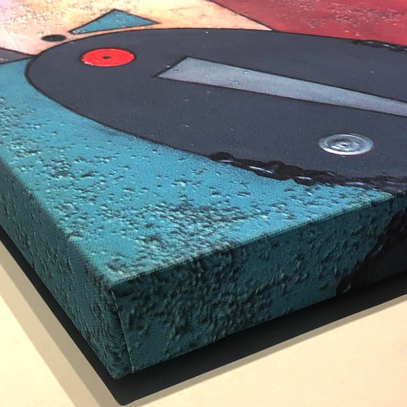 May include: Close-up of a blue canvas painting with geometric shapes and a red circle. The canvas is stretched over a wooden frame and the edges are visible.
