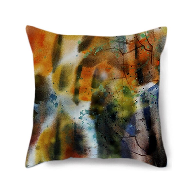 May include: Square throw pillow with an abstract watercolor design. The pillow features a blend of warm colors, including orange, yellow, and brown, with accents of blue and green. The design has a textured appearance, resembling brushstrokes and splatters.