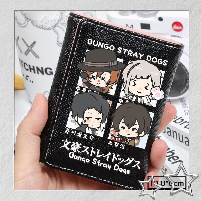 Puede incluir: Cartera negra con interior rosa, con personajes de dibujos animados de "Bungo Stray Dogs." El dise&ntilde;o incluye cuatro retratos de personajes y el texto "Bungo Stray Dogs." Mide aproximadamente 10,8 cm x 8 cm.