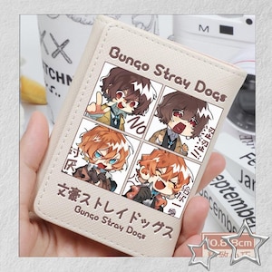Puede incluir: Cartera beige con una ilustraci&oacute;n estilo manga de "Bungo Stray Dogs". El dise&ntilde;o incluye cuatro paneles con arte de personajes y texto japon&eacute;s. La cartera mide aproximadamente 0,68 cm de grosor.