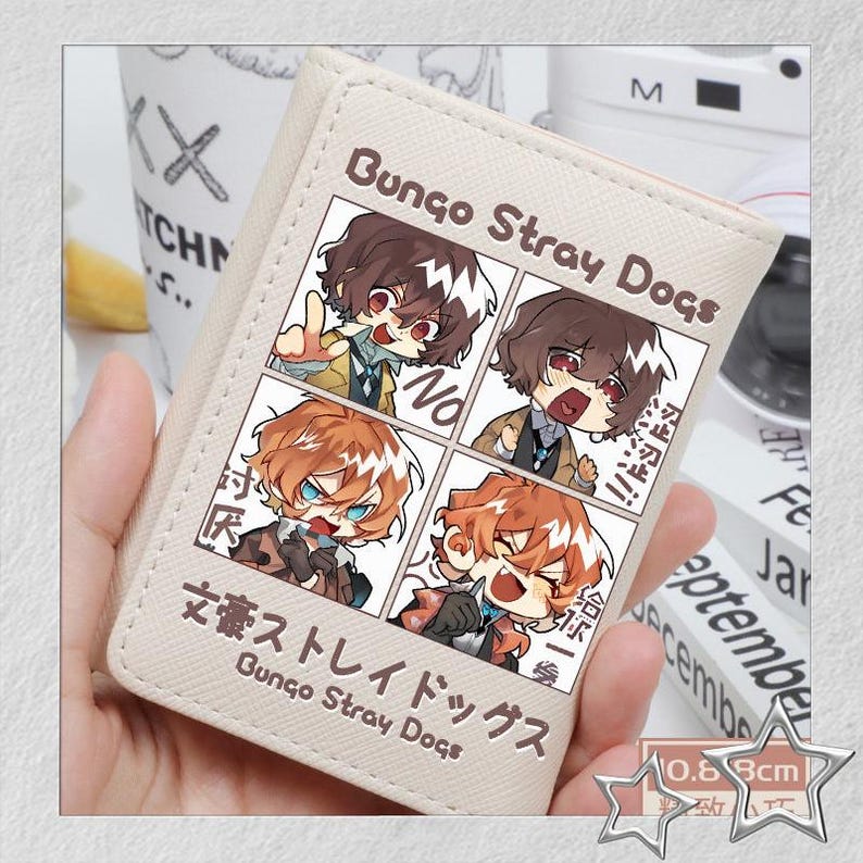 Puede incluir: Cartera beige con una ilustraci&oacute;n estilo manga de "Bungo Stray Dogs". El dise&ntilde;o incluye cuatro paneles con arte de personajes y texto japon&eacute;s. La cartera mide aproximadamente 0,68 cm de grosor.