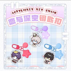 以下が含まれることがあります： アニメスタイルのキャラクターと様々なアクセサリーが付いたアクリルキーホルダー。各キーホルダーは、ピンク、紫、青など、異なる配色になっています。「ACRYLICKEY KEY CHAIN」の文字が上部にあります。