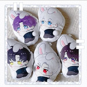May include: Five plush bunny-shaped keychains with anime-style character faces. Each keychain features a different hair color, including purple, white, and black. The characters have large eyes and are wearing black outfits. Each keychain has a small white pom-pom.