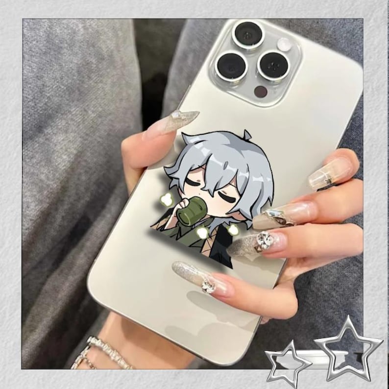 May include: A silver smartphone case featuring a cartoon character with gray hair, drinking from a green cup. The phone has three camera lenses and is held by a person with long, decorated nails. The case is a decorative accessory.