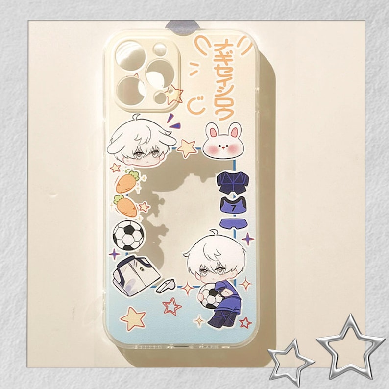 Peut inclure: Coque de t&eacute;l&eacute;phone transparente avec un motif de dessin anim&eacute;. Elle pr&eacute;sente des personnages de style anime, un ballon de football, des carottes et des &eacute;toiles. L'&eacute;tui a un fond bleu clair avec du texte japonais.