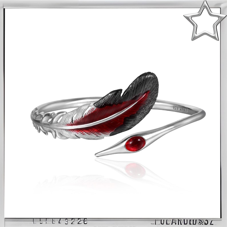Puede incluir: Brazalete de plata con dise&ntilde;o de pluma con detalles de esmalte rojo y negro. La pulsera incluye una gema roja. El dise&ntilde;o de pluma est&aacute; en un lado y la pulsera termina en punta en el otro.