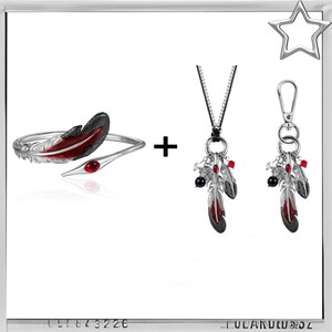 Puede incluir: Un conjunto de joyas plateadas con tem&aacute;tica de plumas. El conjunto incluye una pulsera con un dise&ntilde;o de pluma roja y negra, un collar y un llavero, cada uno con colgantes de plumas con detalles rojos y cuentas negras. Las joyas se exhiben sobre un fondo blanco.