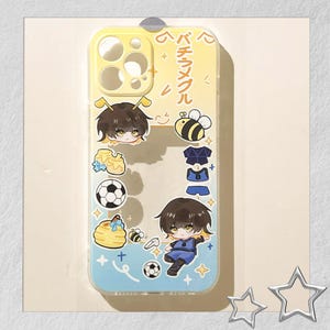 Peut inclure: Une coque de t&eacute;l&eacute;phone transparente avec un d&eacute;grad&eacute; jaune et bleu. La coque pr&eacute;sente des illustrations de dessins anim&eacute;s de personnages d'anime, d'abeilles, de ballons de football et d'un nid d'abeilles. Du texte japonais est imprim&eacute; sur la coque.